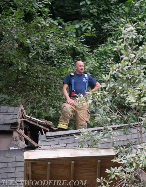 Battalion Chief Sly on the roof peak of the home