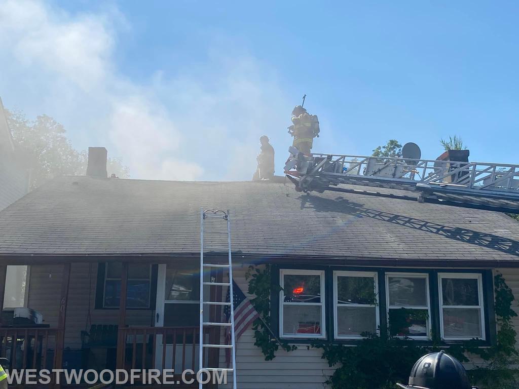 Firefighters ascend to the roof to perform vertical ventilation.
